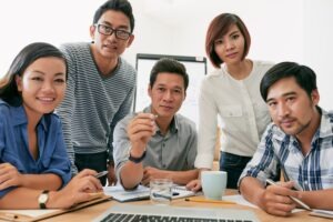 Asian business team looking at camera like at laptop screen